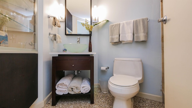 bathroom with walk in shower, vanity, and toilet