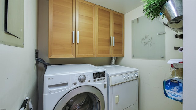 laundry room with cabinets and washer and clothes dryer