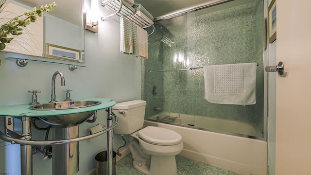 full bathroom featuring toilet, combined bath / shower with glass door, and sink