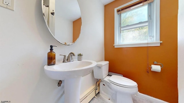 bathroom with baseboard heating, tile patterned floors, and toilet