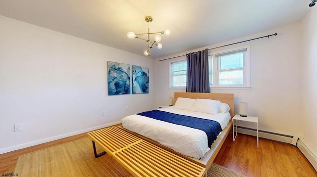 bedroom with a baseboard radiator, a notable chandelier, and hardwood / wood-style flooring