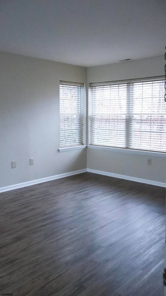 spare room with dark hardwood / wood-style flooring