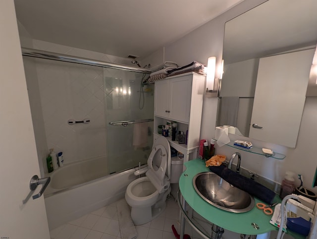 full bathroom featuring shower / bath combination with glass door, tile patterned floors, sink, and toilet