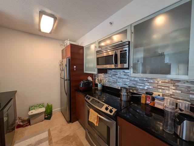 kitchen featuring backsplash, stainless steel appliances, and a textured ceiling