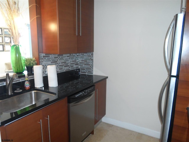 kitchen featuring dark stone countertops, sink, stainless steel appliances, and tasteful backsplash