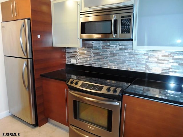 kitchen featuring white cabinetry, stainless steel appliances, and tasteful backsplash