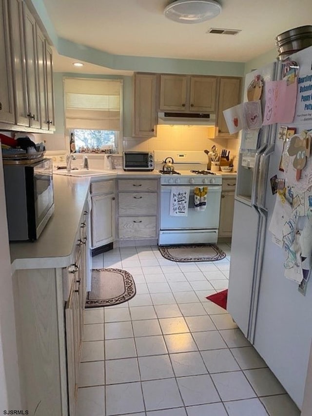 kitchen with sink, light tile patterned floors, white appliances, and light brown cabinets