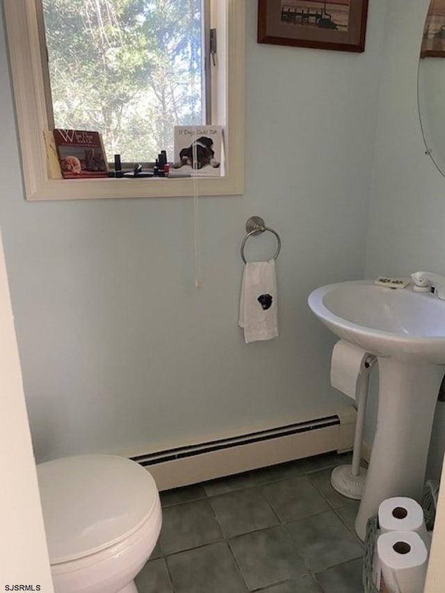 bathroom with tile patterned flooring, a baseboard radiator, and toilet