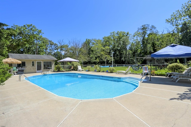 view of swimming pool with a diving board and a patio area