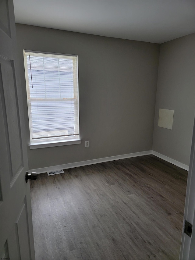 unfurnished room with dark hardwood / wood-style flooring