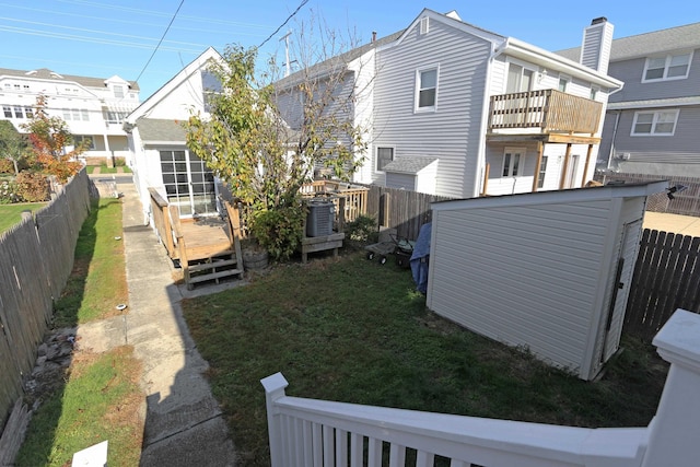 view of yard with a wooden deck and a balcony