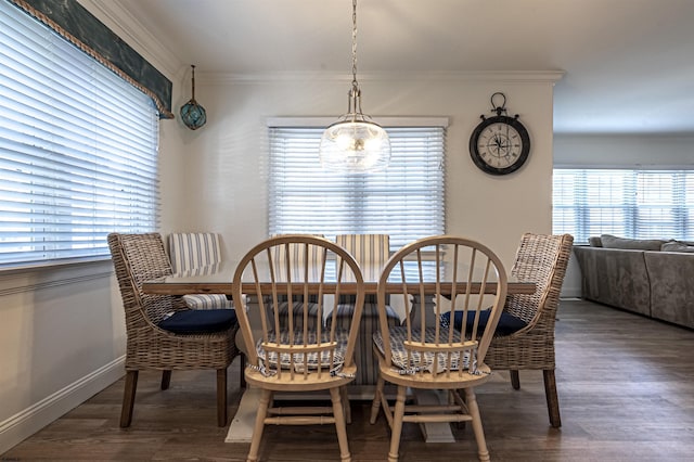 dining space with ornamental molding, dark wood-type flooring, and a healthy amount of sunlight