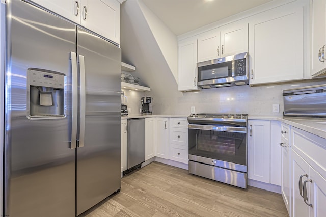 kitchen with backsplash, stainless steel appliances, white cabinetry, and light hardwood / wood-style floors