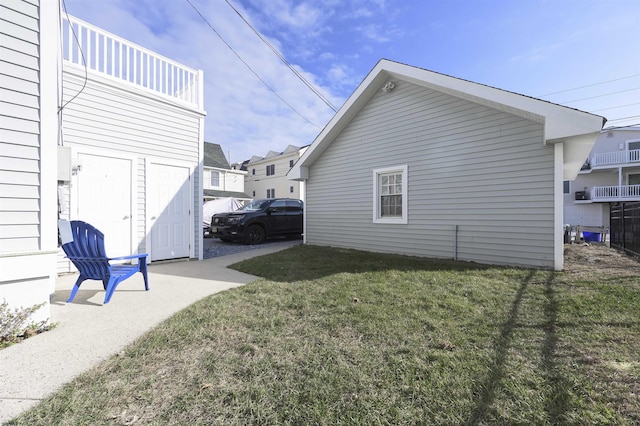 view of side of property with a yard and a balcony