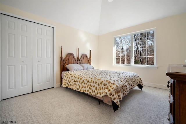 bedroom with light carpet, a closet, and lofted ceiling