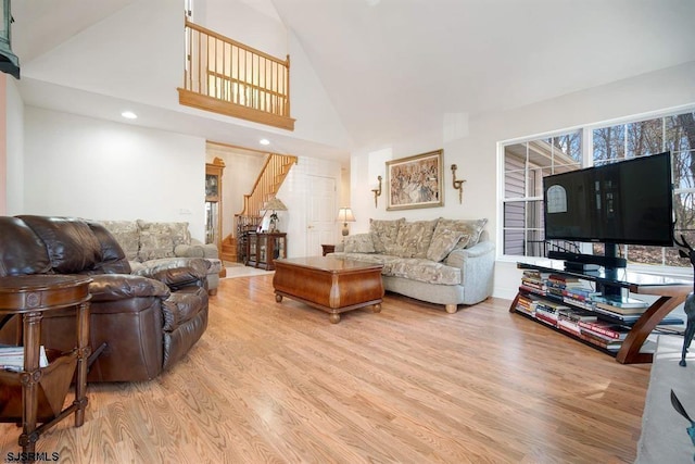 living room with high vaulted ceiling and light hardwood / wood-style floors