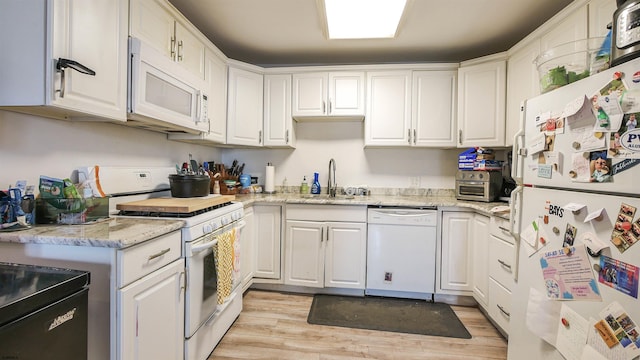 kitchen featuring light stone counters, white appliances, sink, light hardwood / wood-style flooring, and white cabinetry