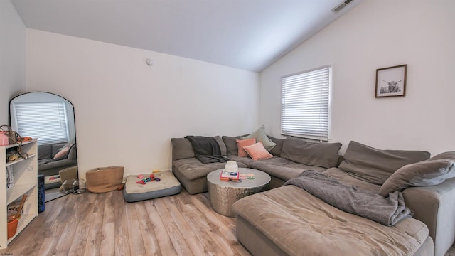 living room featuring light hardwood / wood-style floors and vaulted ceiling