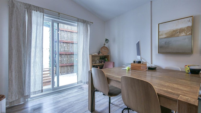 dining room featuring light hardwood / wood-style flooring and lofted ceiling