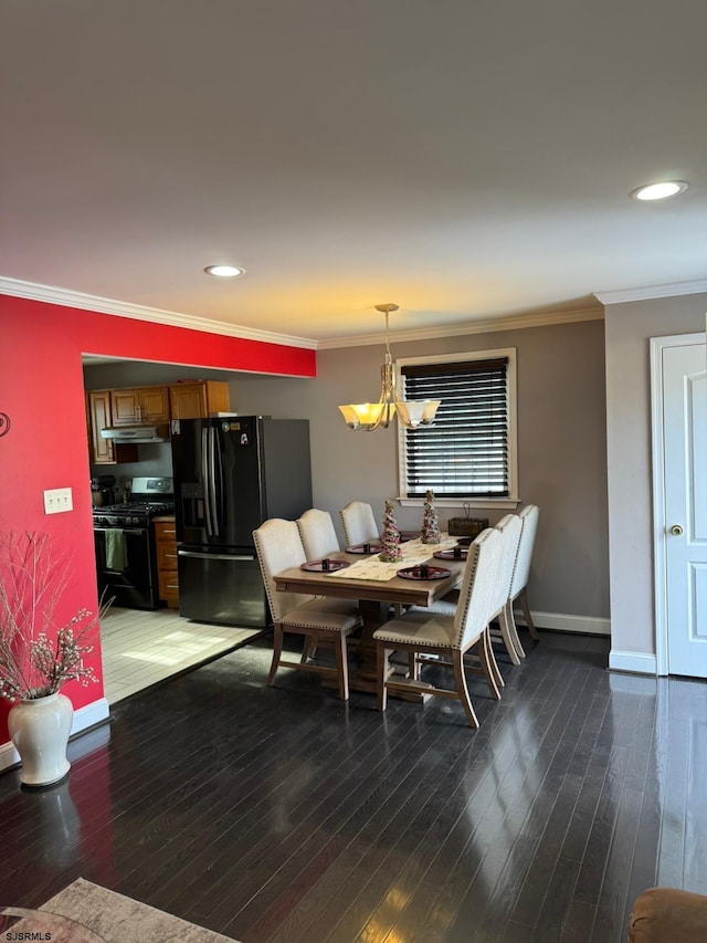 dining room featuring crown molding, hardwood / wood-style floors, and an inviting chandelier