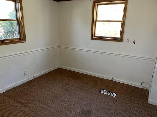 unfurnished room featuring dark carpet