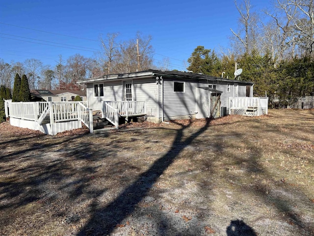 back of house with a yard, cooling unit, and a wooden deck