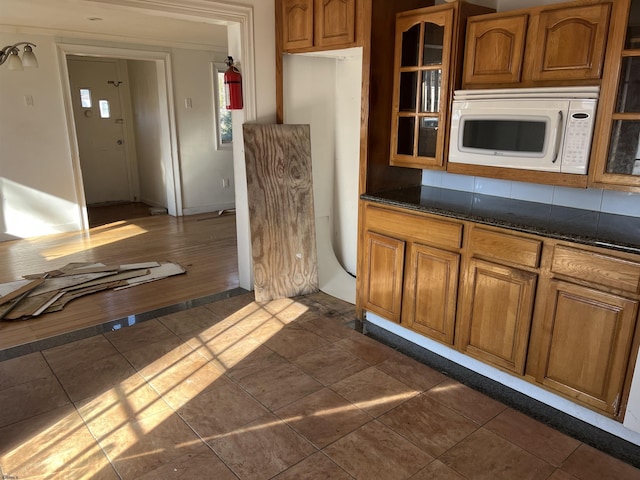 kitchen with dark stone counters and dark wood-type flooring