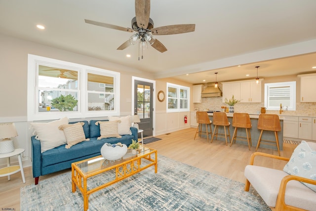 living room with ceiling fan and light hardwood / wood-style floors