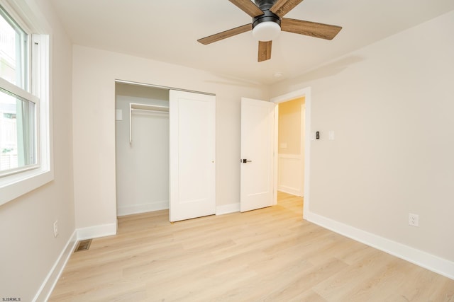 unfurnished bedroom with a closet, light hardwood / wood-style flooring, and ceiling fan