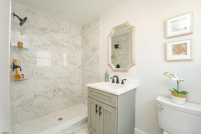 bathroom with tiled shower, vanity, and toilet