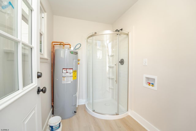 bathroom with hardwood / wood-style flooring, walk in shower, and water heater