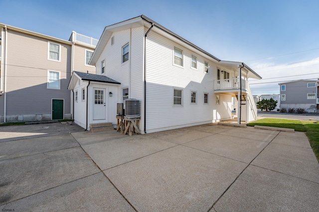 rear view of property with a balcony and central AC unit