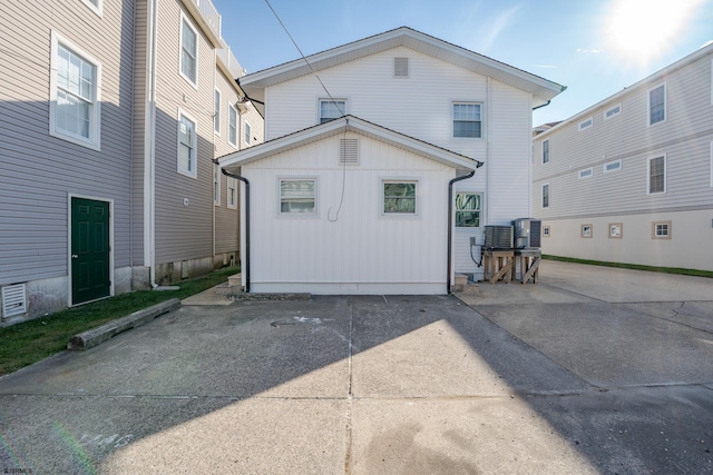 back of house with central AC unit