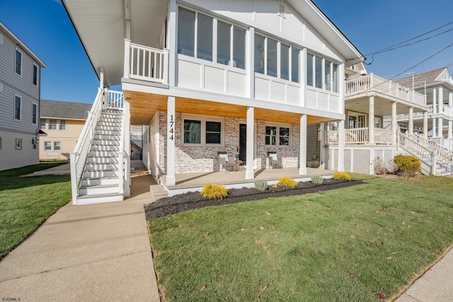 rear view of property with a lawn and a porch