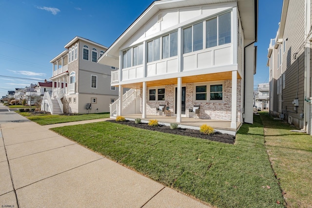 view of front of home with a front yard and covered porch