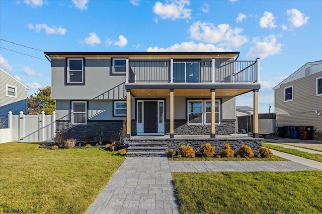 view of front of house featuring a balcony and a front lawn