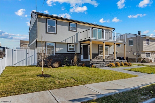 view of front of home featuring a balcony and a front yard