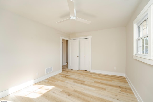 unfurnished bedroom with a closet, light hardwood / wood-style floors, and ceiling fan