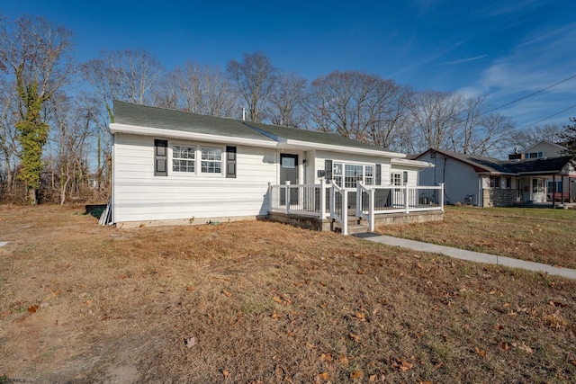 ranch-style home featuring a front lawn and a deck