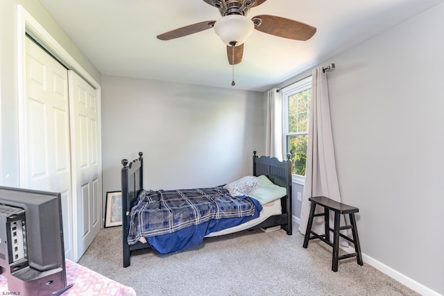 bedroom featuring ceiling fan, light carpet, and a closet