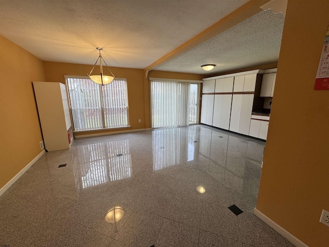 unfurnished dining area with a textured ceiling