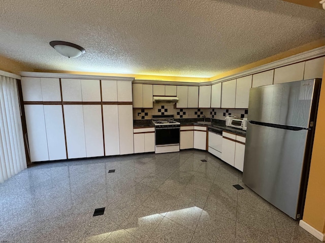 kitchen featuring white appliances, sink, a textured ceiling, tasteful backsplash, and white cabinetry