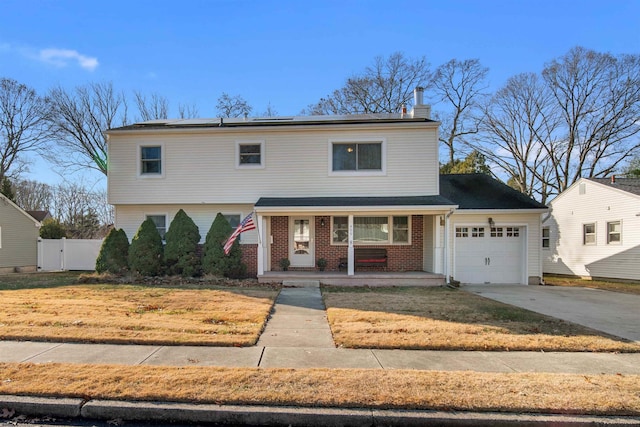 front of property featuring a front yard, a porch, and a garage