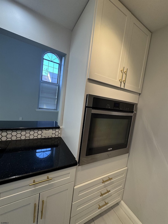 kitchen with stainless steel oven and white cabinets