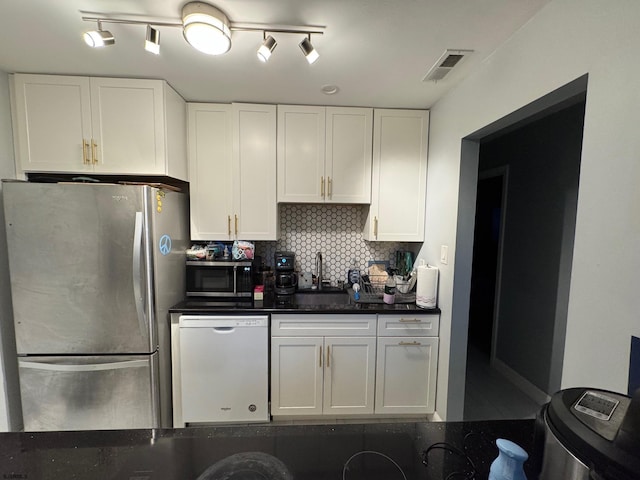 kitchen with white cabinets, backsplash, stainless steel refrigerator, and dishwasher