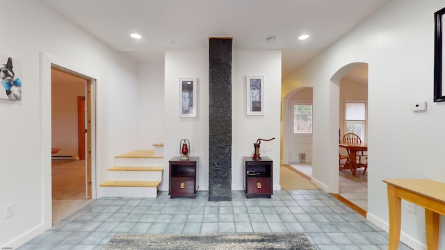 hallway with light tile patterned floors and a baseboard radiator