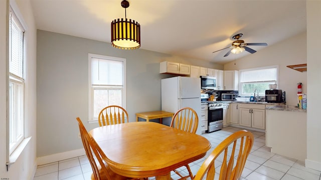 dining room featuring ceiling fan, lofted ceiling, sink, and light tile patterned floors