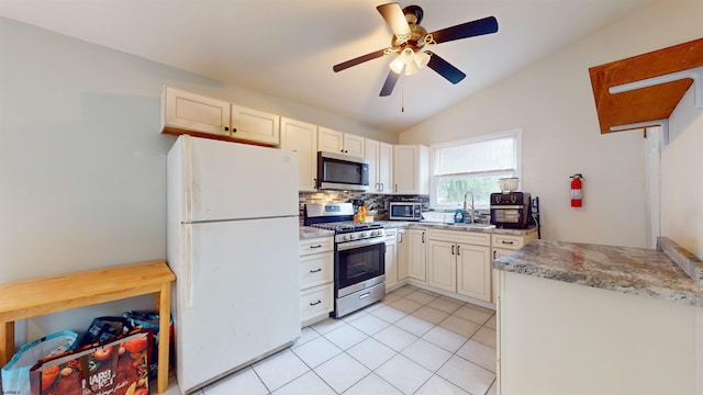 kitchen with ceiling fan, sink, stainless steel appliances, backsplash, and vaulted ceiling