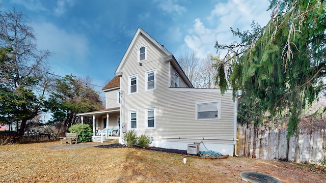 rear view of house with a lawn and covered porch