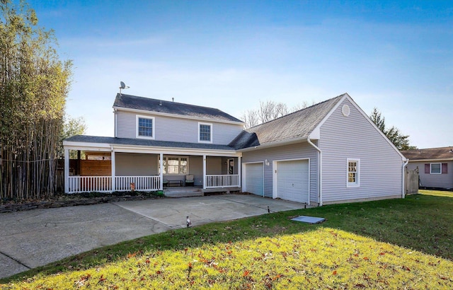 view of front of property featuring covered porch, a front yard, and a garage